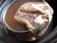 肉骨茶（バクテー）の素材セットから中薬包みを取り出す