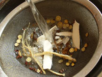 薬膳スープの素材を洗う